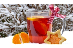 Vianočný punč s pomarančom položený v snehu s lineckým koláčikom a mandarínkou