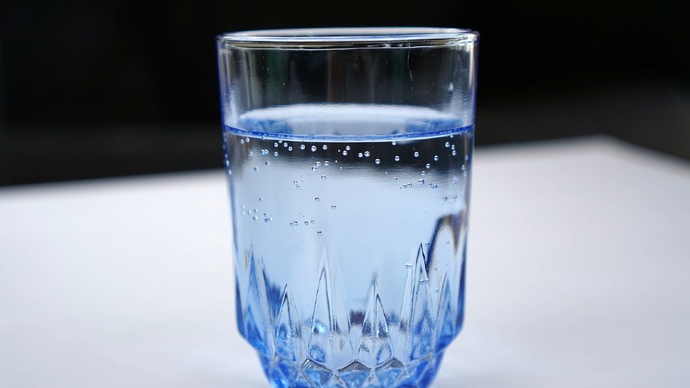 voda v modrom sklenenom pohári